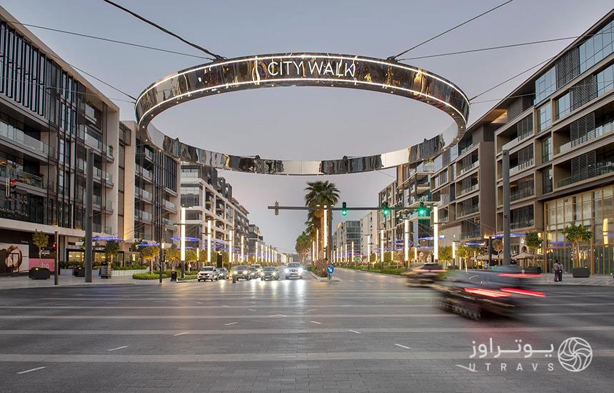 تصویری از «سیتی‌واک» دبی؛ حلقه‌ای فلزی‌ در ارتفاع بالایی از خیابان نصب شده و عبارت «city walk» روی آن حک شده‌است. 